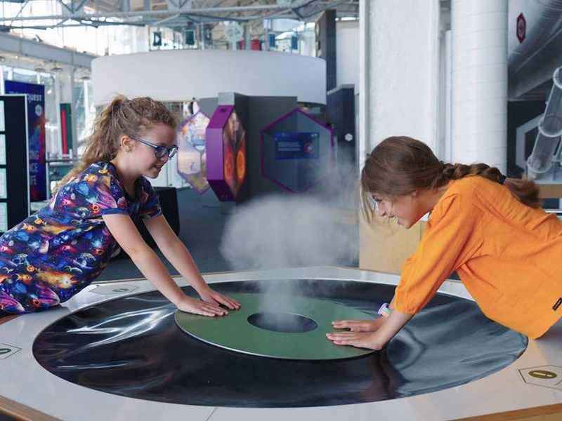 Two children play with an interactive exhibit at Techniquest