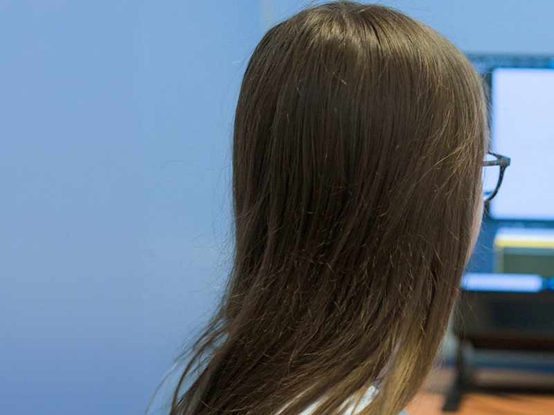 A person sits facing a computer screen.