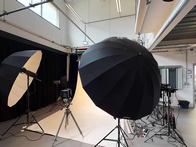 Photography shooting area with camera between two large lights pointed at a white background