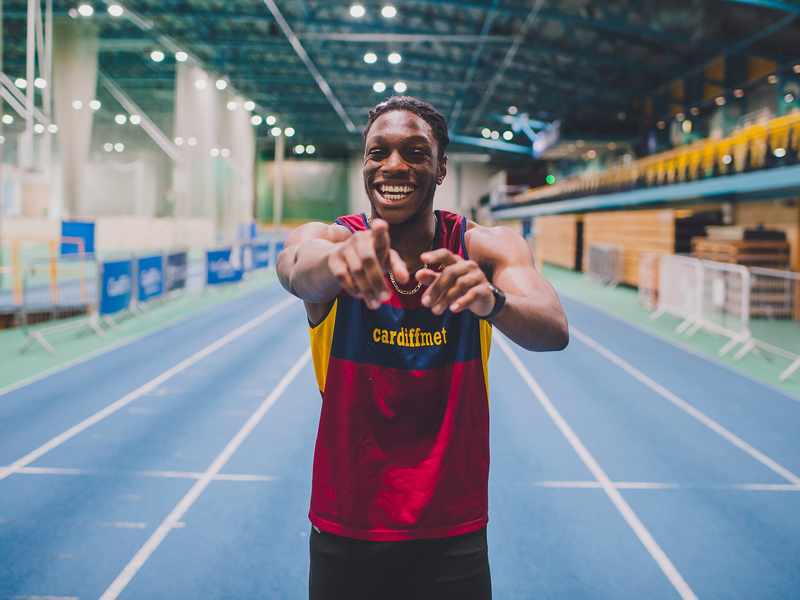Cardiff Met athlete smiling and pointing at the camera in the winning mood.