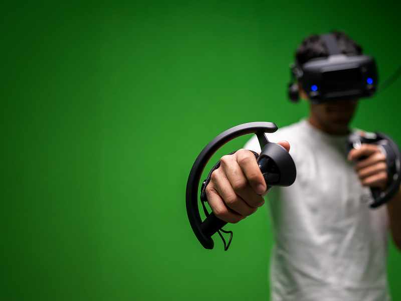 A student holding virtual reality googles and handset