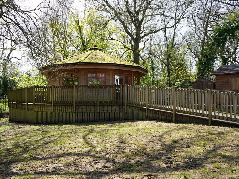 A round wooden building with wooden ramp and surrounding decking