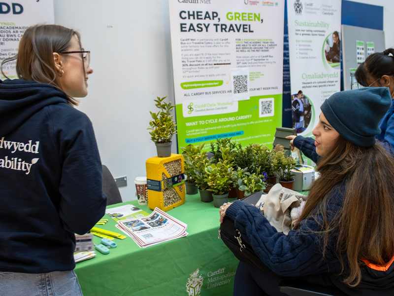 A member of staff talks with a student at a Sustainability information booth