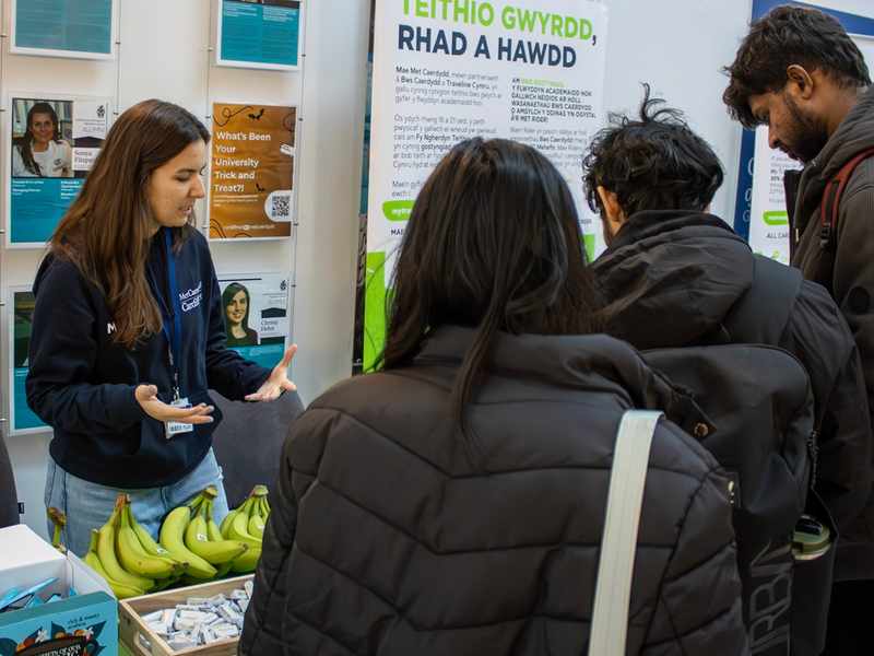 A member of the Sustainability team engages in conversation with students at a Go Green Week information stall