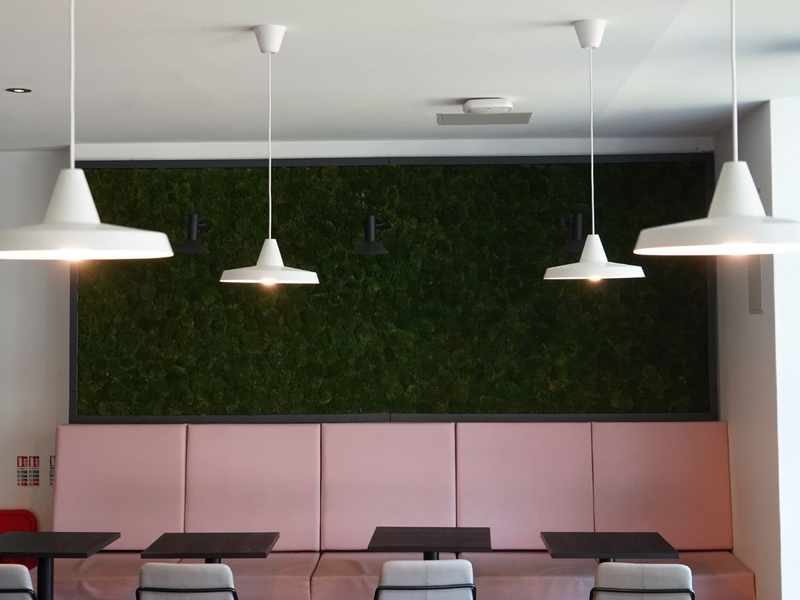 A collection of hanging lights above common area seating on Cardiff Met campus
