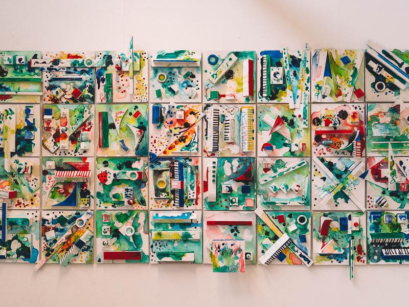 A vibrant wall hanging featuring an array of colourful pieces arranged in an artistic design.