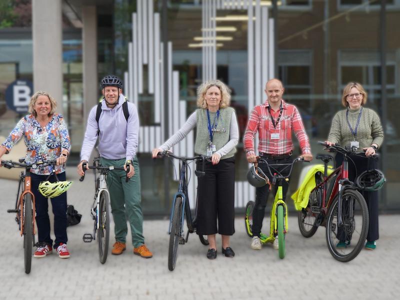 A group of Cardiff Met staff stand with their bicycles