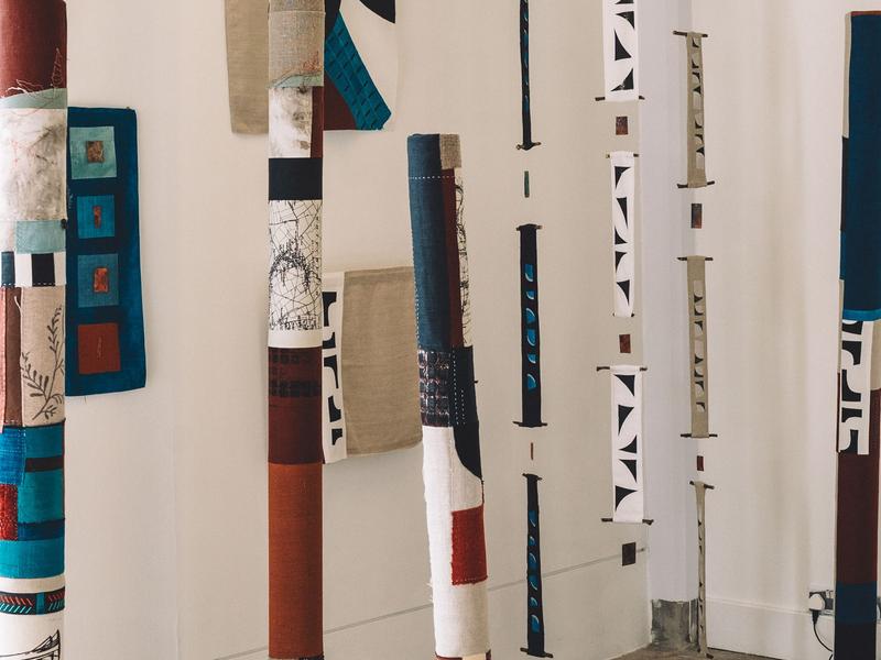 A collection of textile columns in an open art space