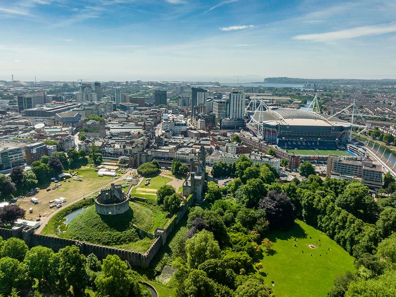 A city skyline featuring a large park in the foreground and a prominent building in the background.
