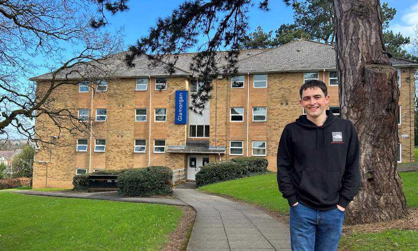 Lloyd Tandy standing outside an accommodation block at Plas Gwyn.