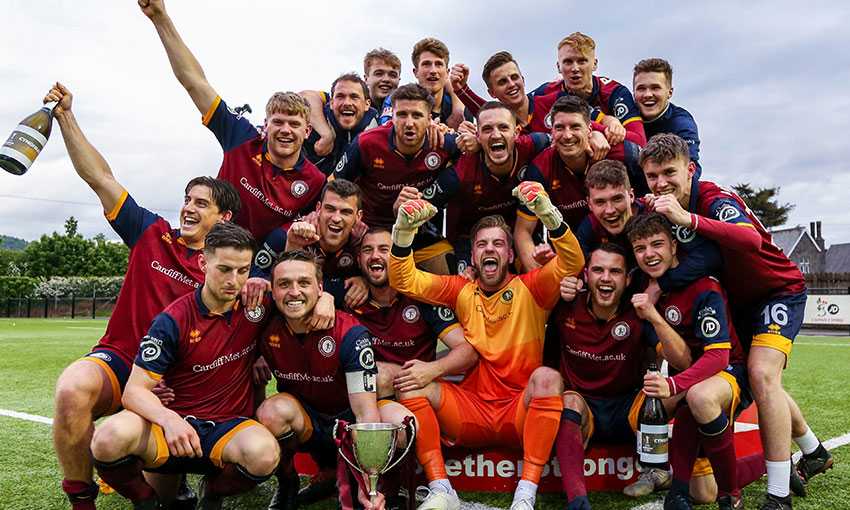Cardiff Met Football Club team celebrate and pose with a trophy