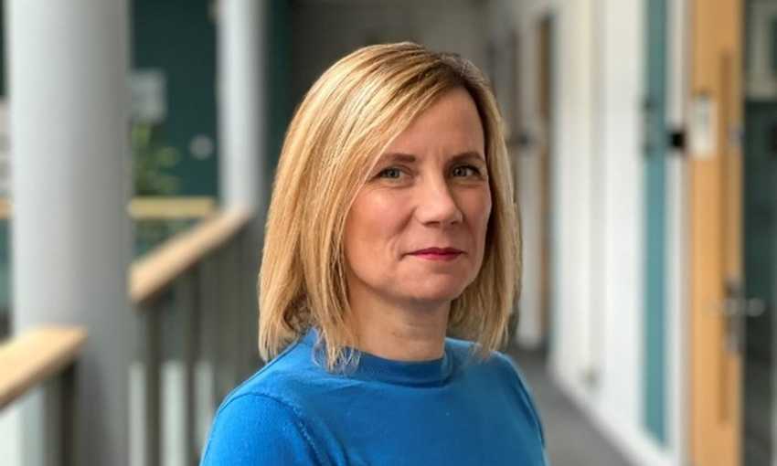 Headshot of Lowri Williams standing in one of the open corridors of the School of Management building