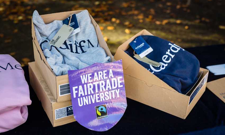 Cardiff Met-branded Fairtrade merchandise stacked in boxes alongside a 
