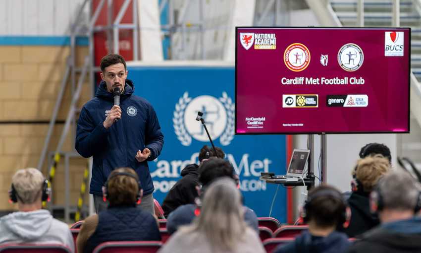 A person giving a talk to visitors at an Open Day Information Fair.