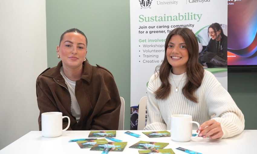 Sustainability volunteers sit at an information booth