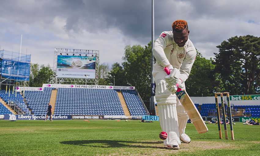 Cricketer swings the bat for the ball during a game of cricket