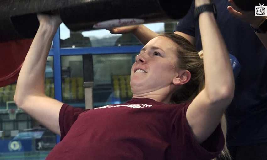 Student lifts barbell on benchpress during exercise