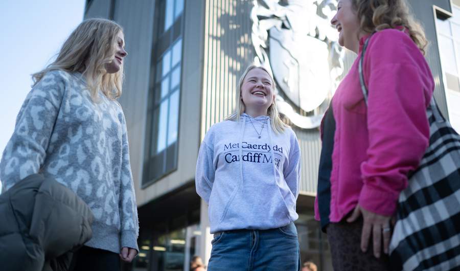 Student holding a Campus Tours Sign