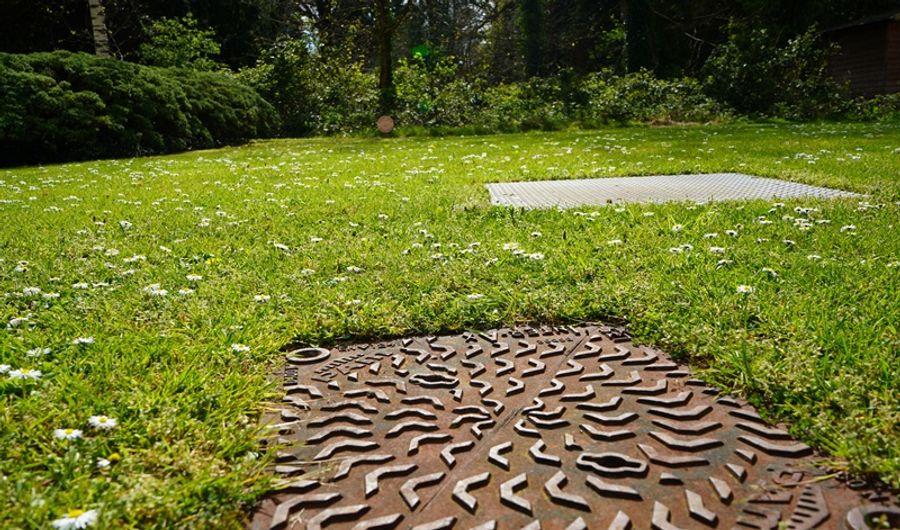Manhole cover in a field of grass