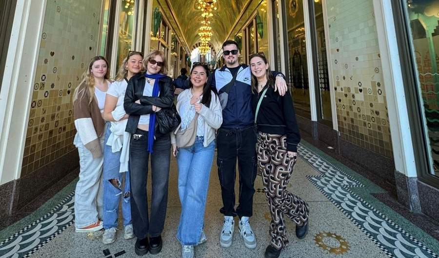 A group of people stand together in an ornately decorated arcade.