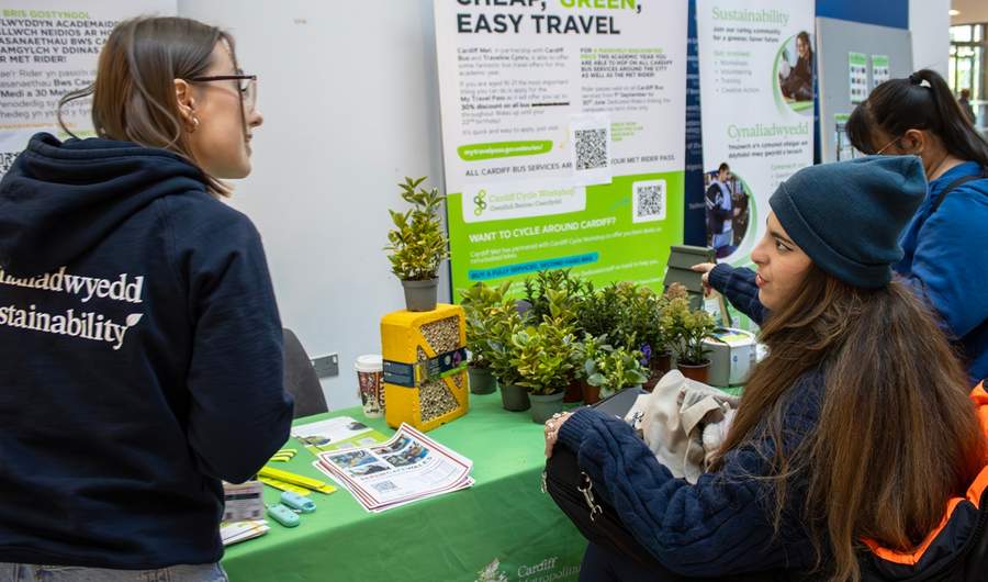 A member of staff talks with a student at a Sustainability information booth