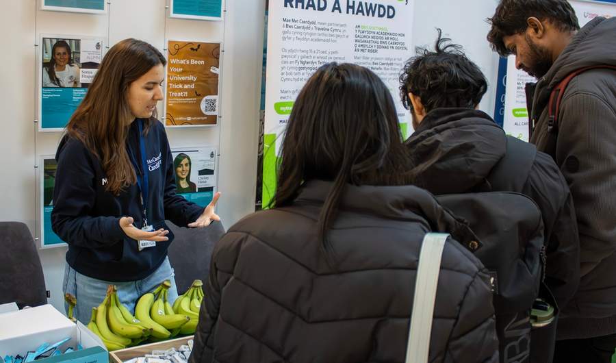 A member of the Sustainability team engages in conversation with students at a Go Green Week information stall