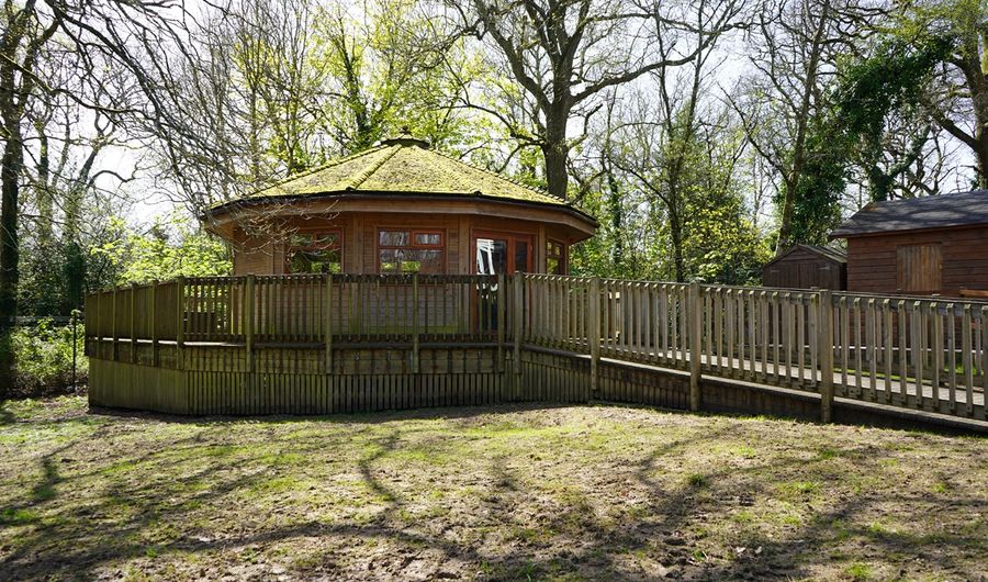 A round wooden building with wooden ramp and surrounding decking