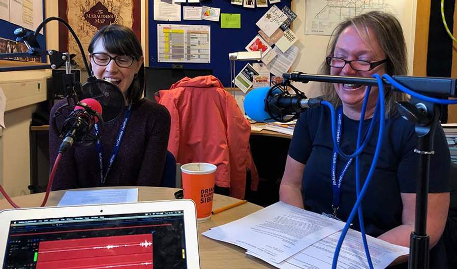 Lecturers sat in front of microphones at a round table in discussion