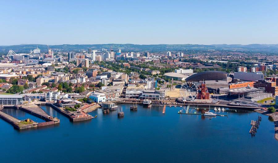 Aerial view of Mermaid Quay in Cardiff Bay, with the city of Cardiff in the background.