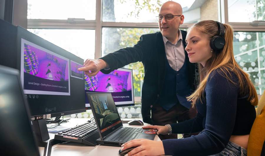Lecturer and student using computer workstation