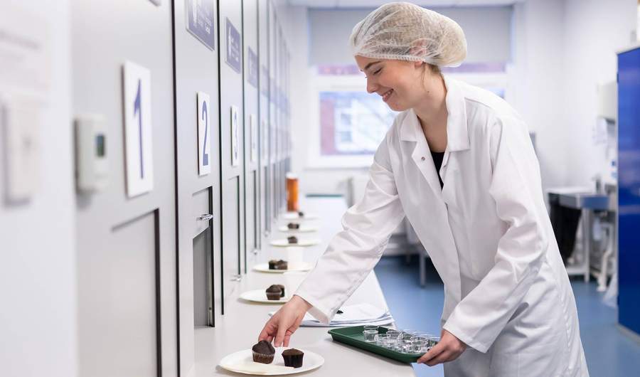 Student places cakes out for testing in Food Industry Centre evaluation suite