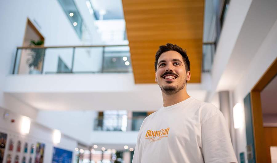 A person stands in a brightly lit atrium space.