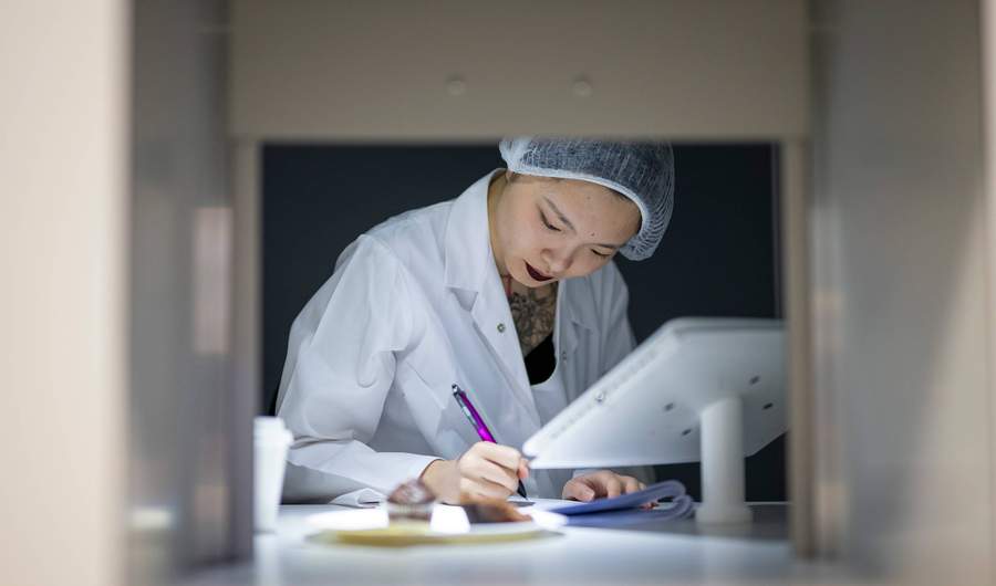 Student writing notes in Food Industry Centre evaluation suite