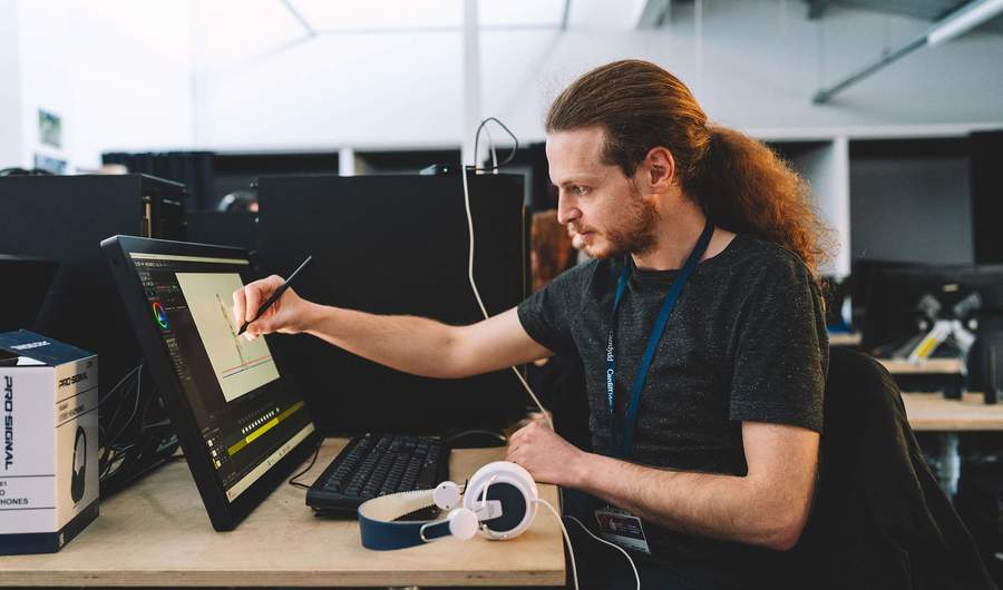 A student draws on a pen display using a stylus.