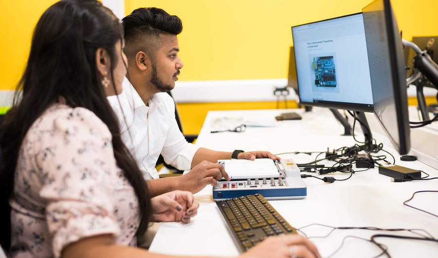 Two engineering students use a breadboard for circuit prototyping