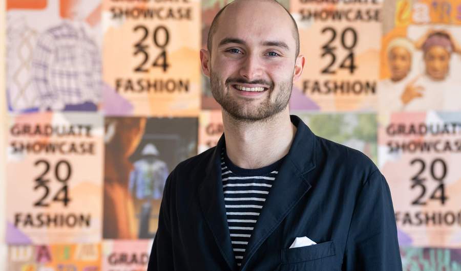A person stands in front of a collage of posters.