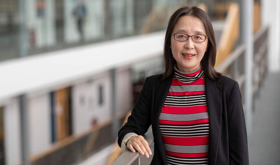 A person leans against a railing in an open atrium space.