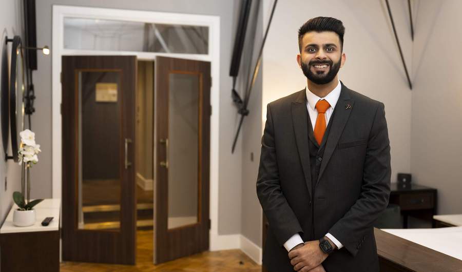 A person stands in the foyer of a stylish hotel.