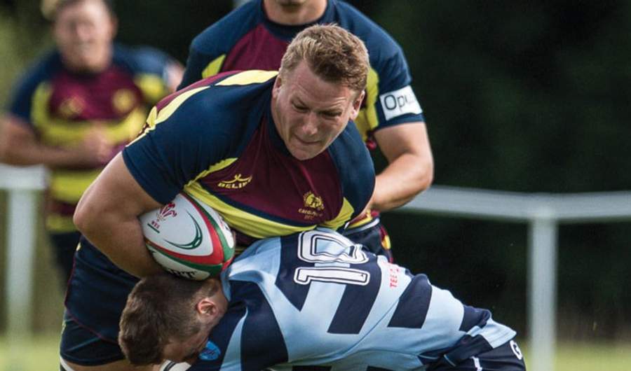 Alex Dombrandt gets tackled around the waist during a game of rugby