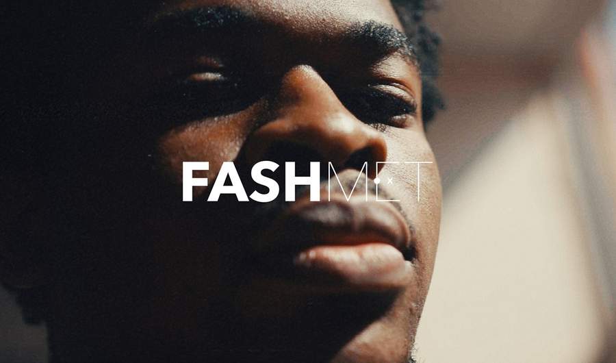 A young man looks into the camera with the text 'FashMet' in front of his face