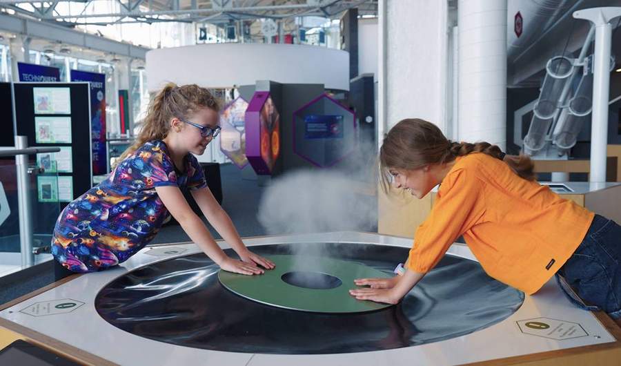 Two children play with an interactive exhibit at Techniquest