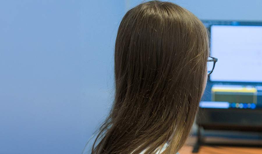A person sits facing a computer screen.