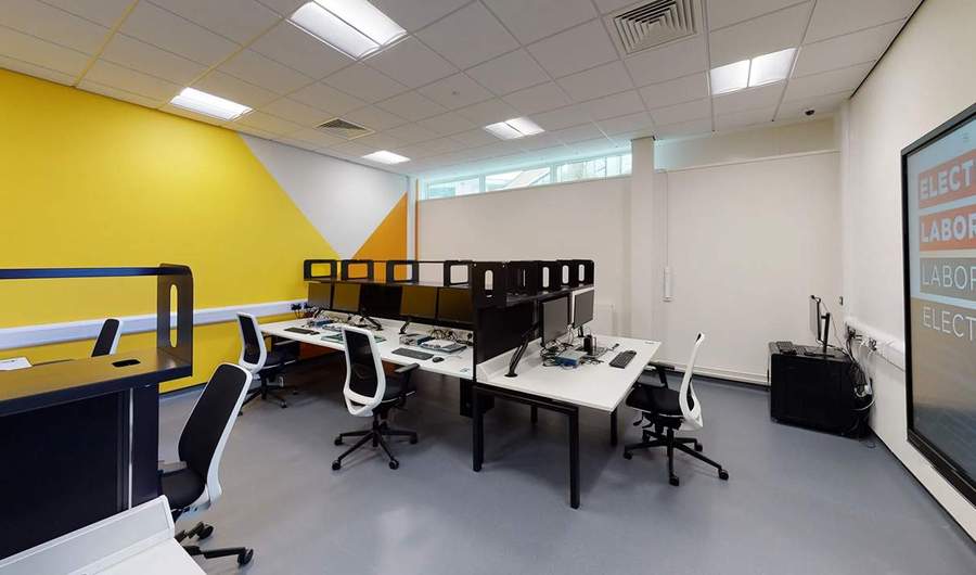 Wide view of computer desks in a bright open room.