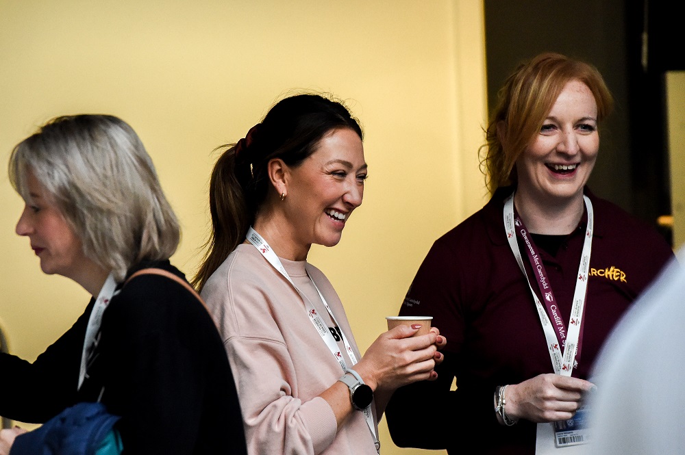 Two ArcHER attendees stood smiling and laughing