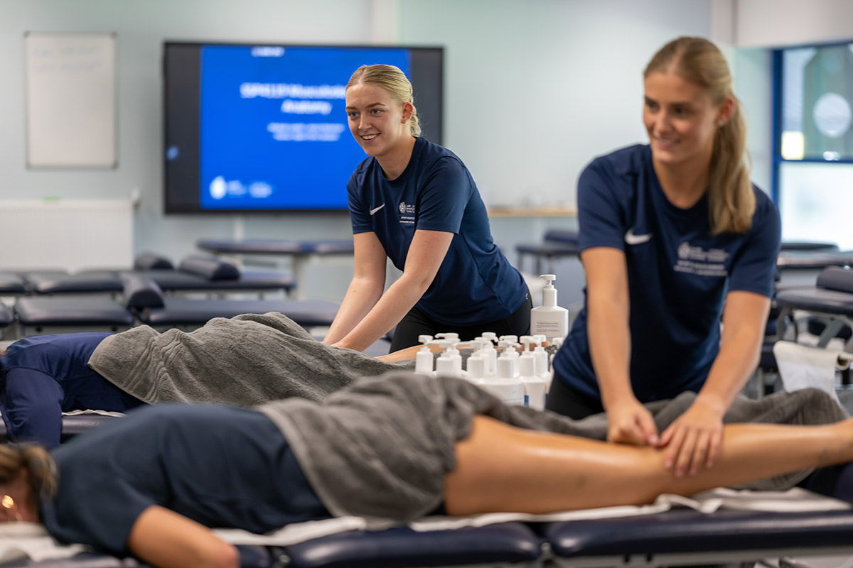 Two women relaxing during massage treatments in a peaceful room, inside Cardiff Met's Sports Injury Clinic