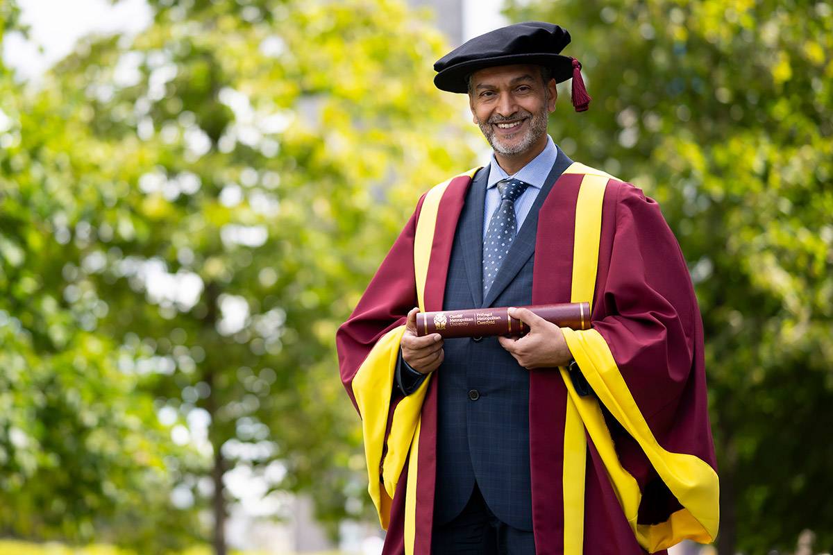 Umar Hussain holding their Honorary Doctorate