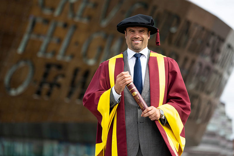 Jamie Roberts holding their Honorary Fellowship