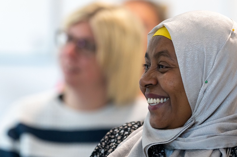 Adult learner in headscarf smiles during a lesson