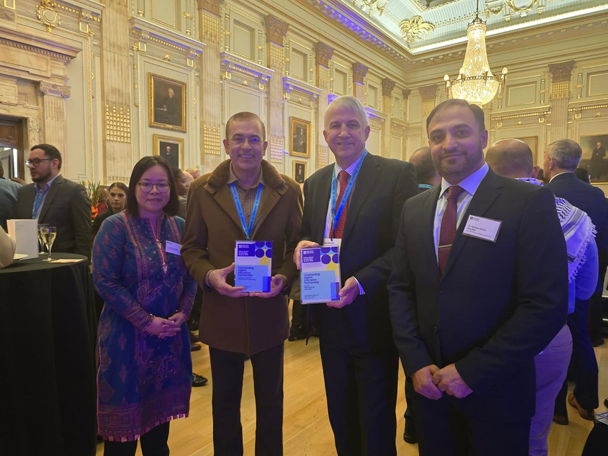 Four individuals stand in a room, proudly holding their awards, celebrating their achievements together.