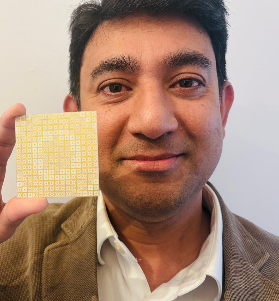 Dr Jasmin Uddin holds a small, flat-panel antenna in their hand